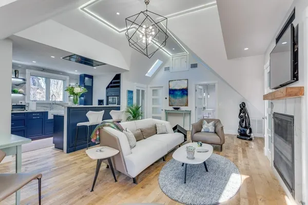 a living room with furniture a fireplace and a chandelier
