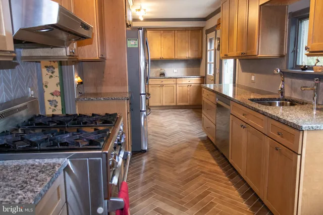 a kitchen with stainless steel appliances granite countertop a stove a sink and a refrigerator