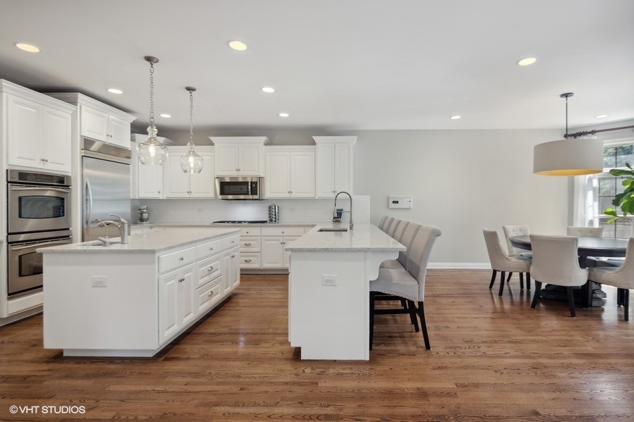 438 West 3rd Street Elmhurst, IL 60126 - Photo 11 of 43 a large white kitchen with lots of counter space dining table and stainless steel appliances