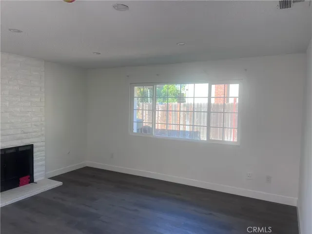 an empty room with wooden floor and a window