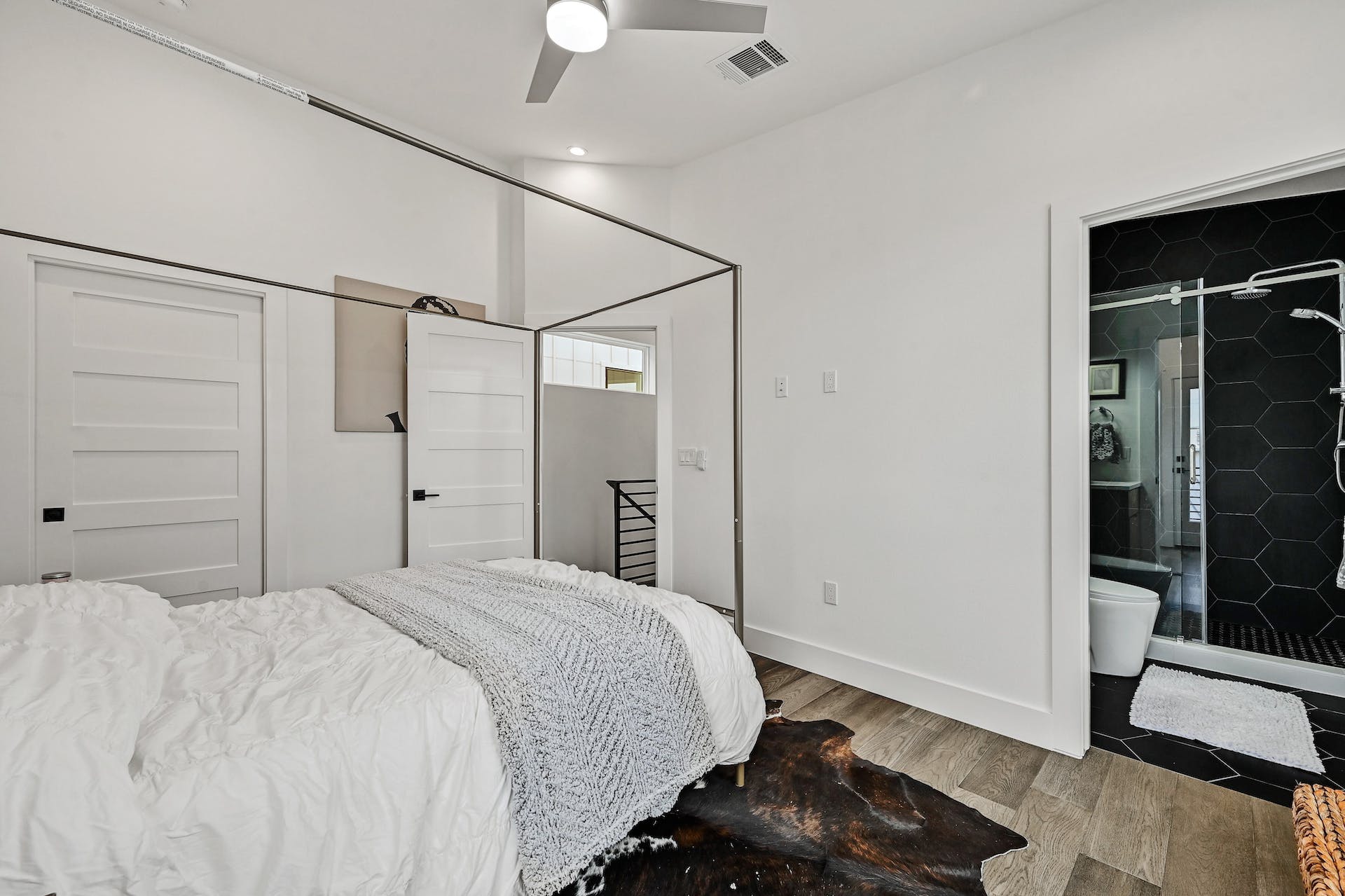 201 Tillery Square, Unit 2 Austin, TX 78702 - Photo 13 of 20 Bedroom with wood finished floors, a ceiling fan, and ensuite bathroom
