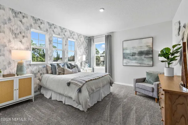 a bedroom with a bed and a painting on the wall