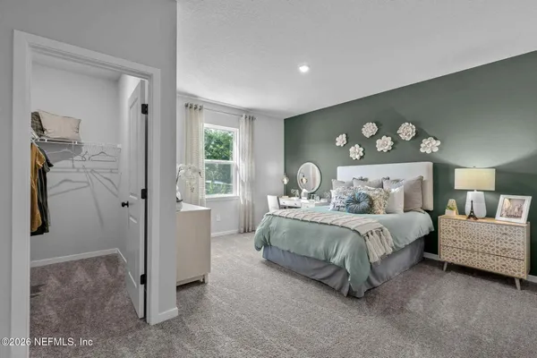 a bedroom with a large bed and a chandelier