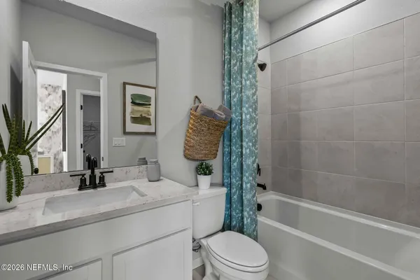 a bathroom with a granite countertop sink a mirror a vanity and a shower