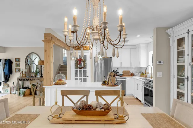 a living room with fireplace furniture and a kitchen view
