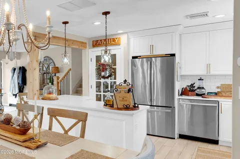 a kitchen with stainless steel appliances granite countertop a refrigerator a oven and white cabinets