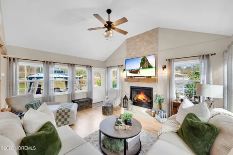 a living room with furniture fireplace and a large window