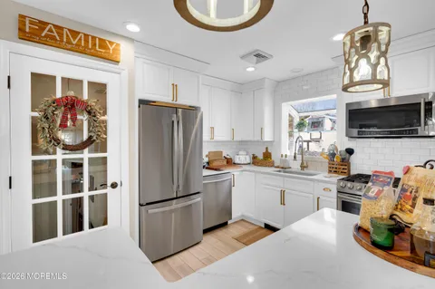 a kitchen with stainless steel appliances granite countertop a refrigerator stove top oven a sink and dishwasher