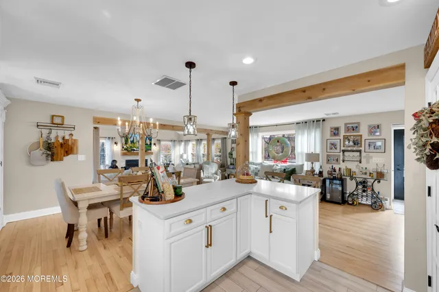 a kitchen with stainless steel appliances white cabinets and wooden floor