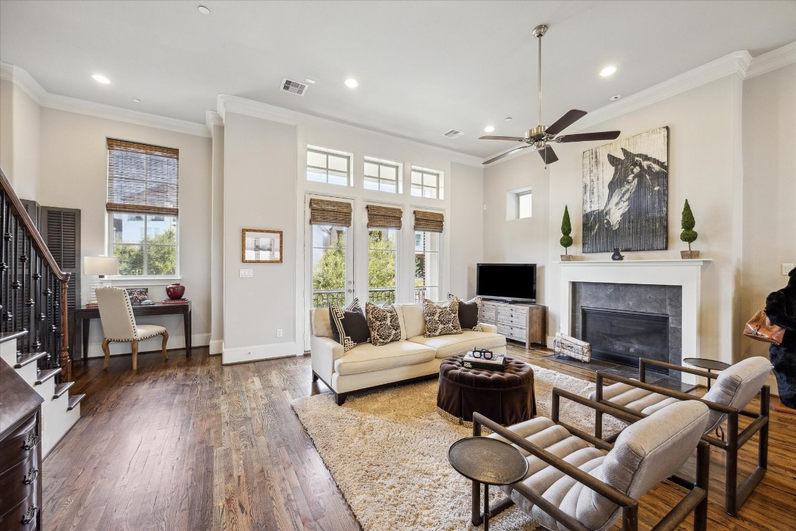 9634 Kings Cross Station Houston, TX 77045 - Photo 4 of 24 LIVING ROOM II - Custom blinds and wall of windows with a balcony overlooking the lush green space.