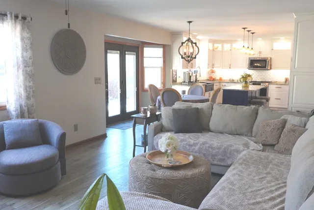 a view of a dining room with furniture a chandelier and wooden floor
