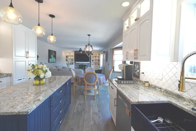 a kitchen with granite countertop kitchen island stainless steel appliances a sink stove and center island