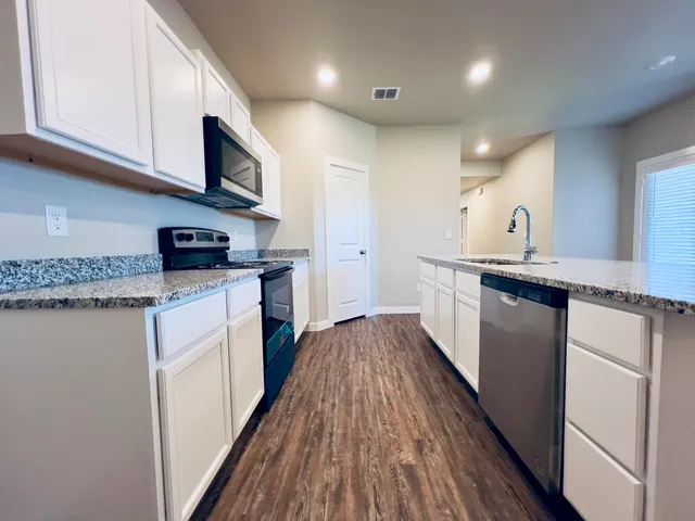 a kitchen with a sink a microwave and cabinets