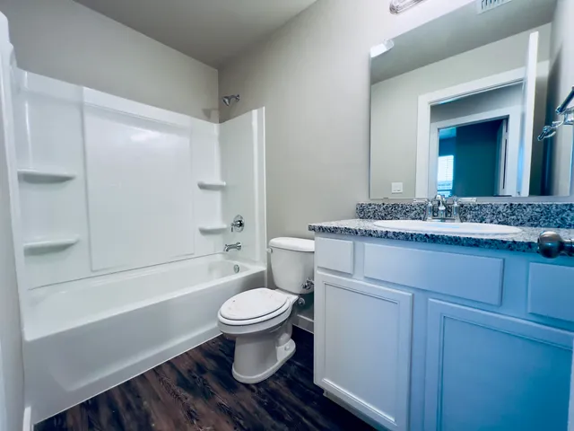 a bathroom with a granite countertop toilet a sink and bathtub