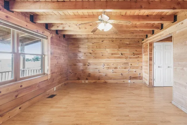 a view of empty room with wooden floor