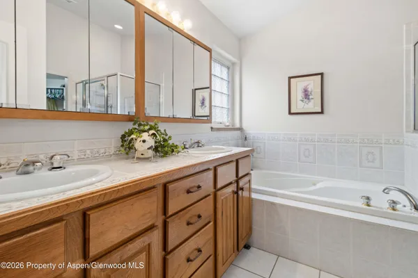 a bathroom with a sink a large mirror and a bathtub