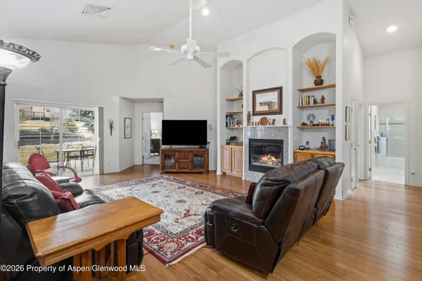 a living room with furniture a flat screen tv and a fireplace