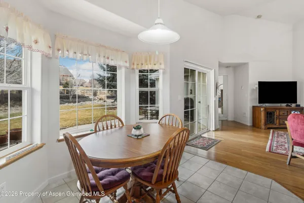 a living room with furniture a flat screen tv and kitchen view