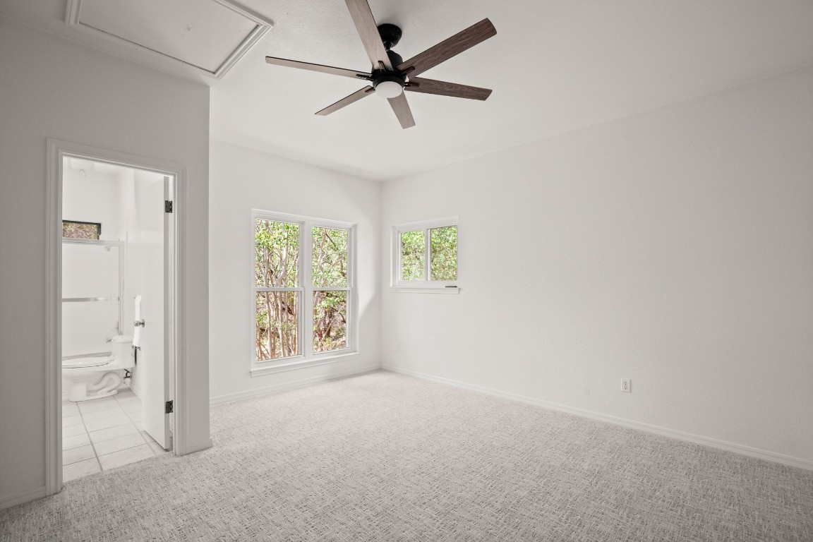 4906 Bob Cat Run Austin, TX 78731 - Photo 18 of 37 Spare room featuring ceiling fan and light colored carpet