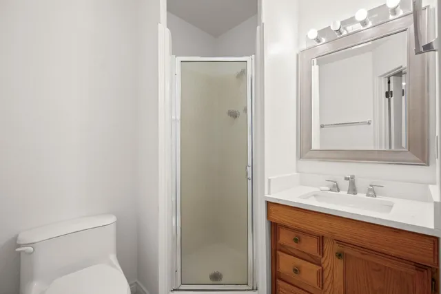 a bathroom with a toilet a sink a vanity and mirror