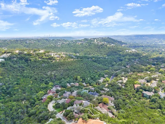 a view of a city with lush green forest