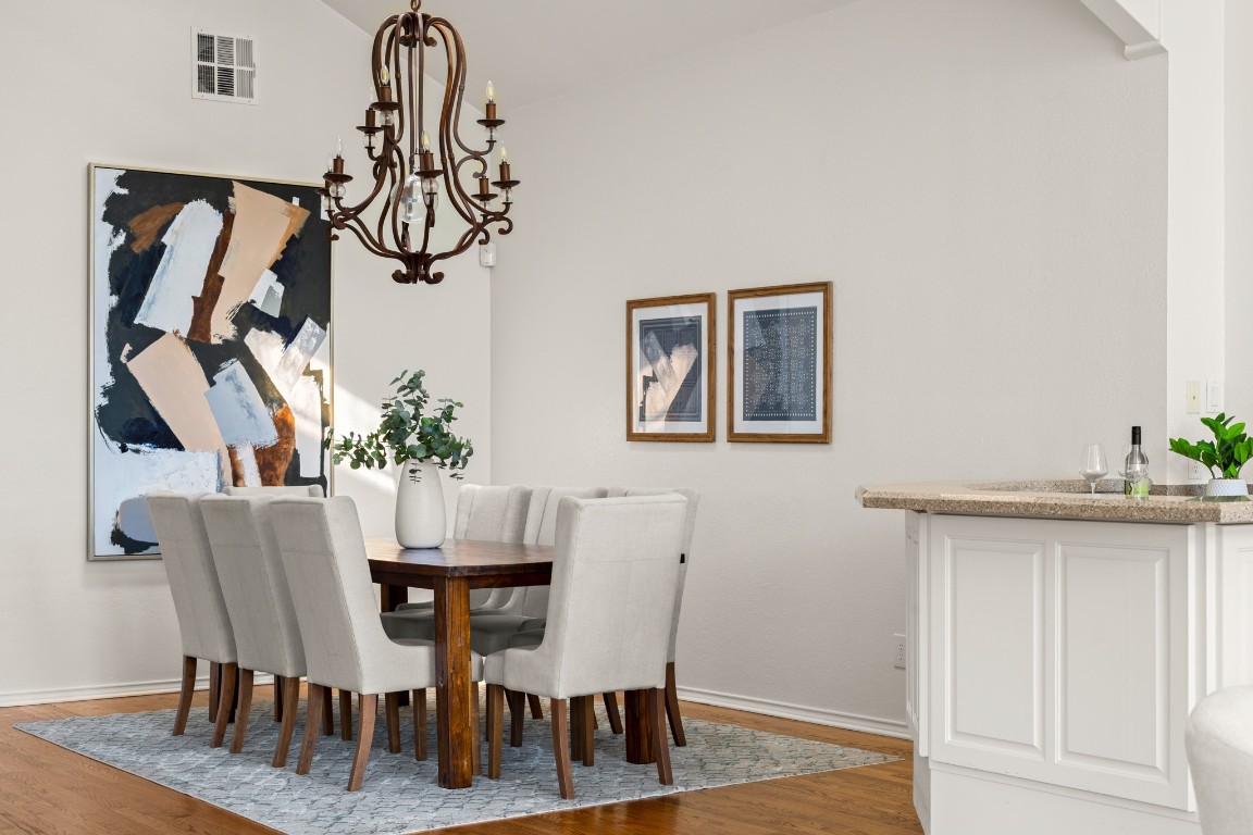 4906 Bob Cat Run Austin, TX 78731 - Photo 5 of 37 Dining space featuring light wood-type flooring, a chandelier, and lofted ceiling