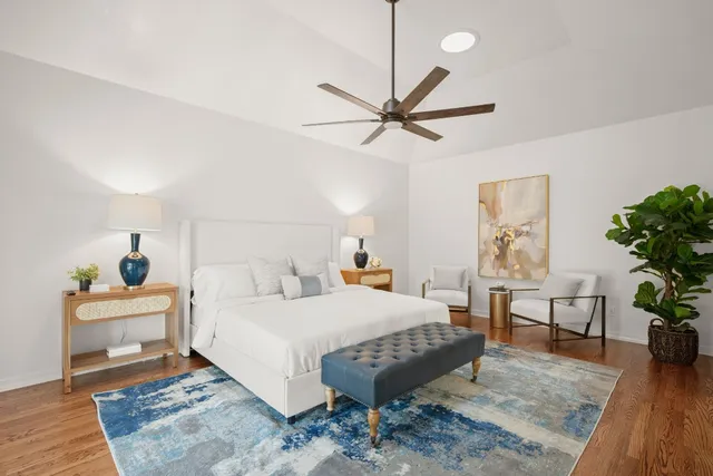 a bedroom with a bed a chandelier and potted plant on the table