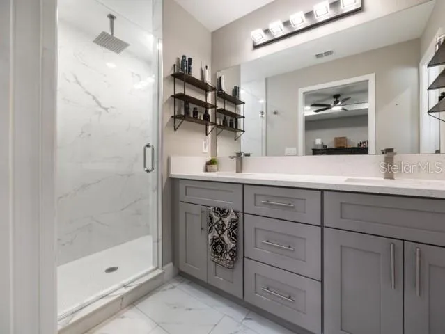 a bathroom with a granite countertop sink a shower and a mirror