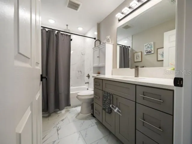 a bathroom with a double vanity sink toilet and shower