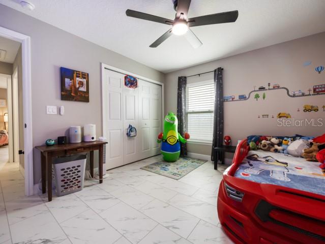 156 Juniper Circle Ocala, FL 34480 - Photo 19 of 40 a bedroom with a bed and a chandelier