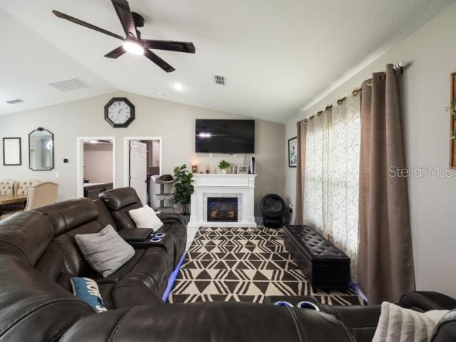 156 Juniper Circle Ocala, FL 34480 - Photo 3 of 40 a living room with furniture a fireplace and a flat screen tv