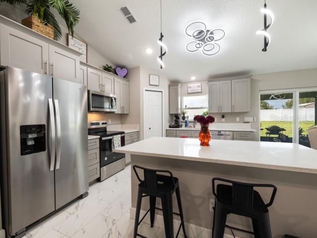 156 Juniper Circle Ocala, FL 34480 - Photo 6 of 40 a kitchen with stainless steel appliances a table chairs refrigerator and microwave
