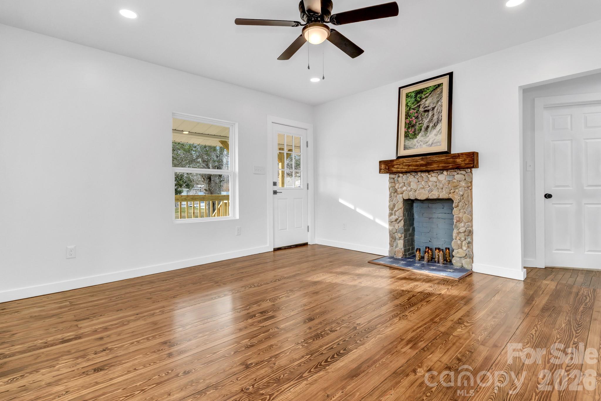 246 Marion Street Marion, NC 28752 - Photo 15 of 48 a view of empty room with wooden floor and fireplace