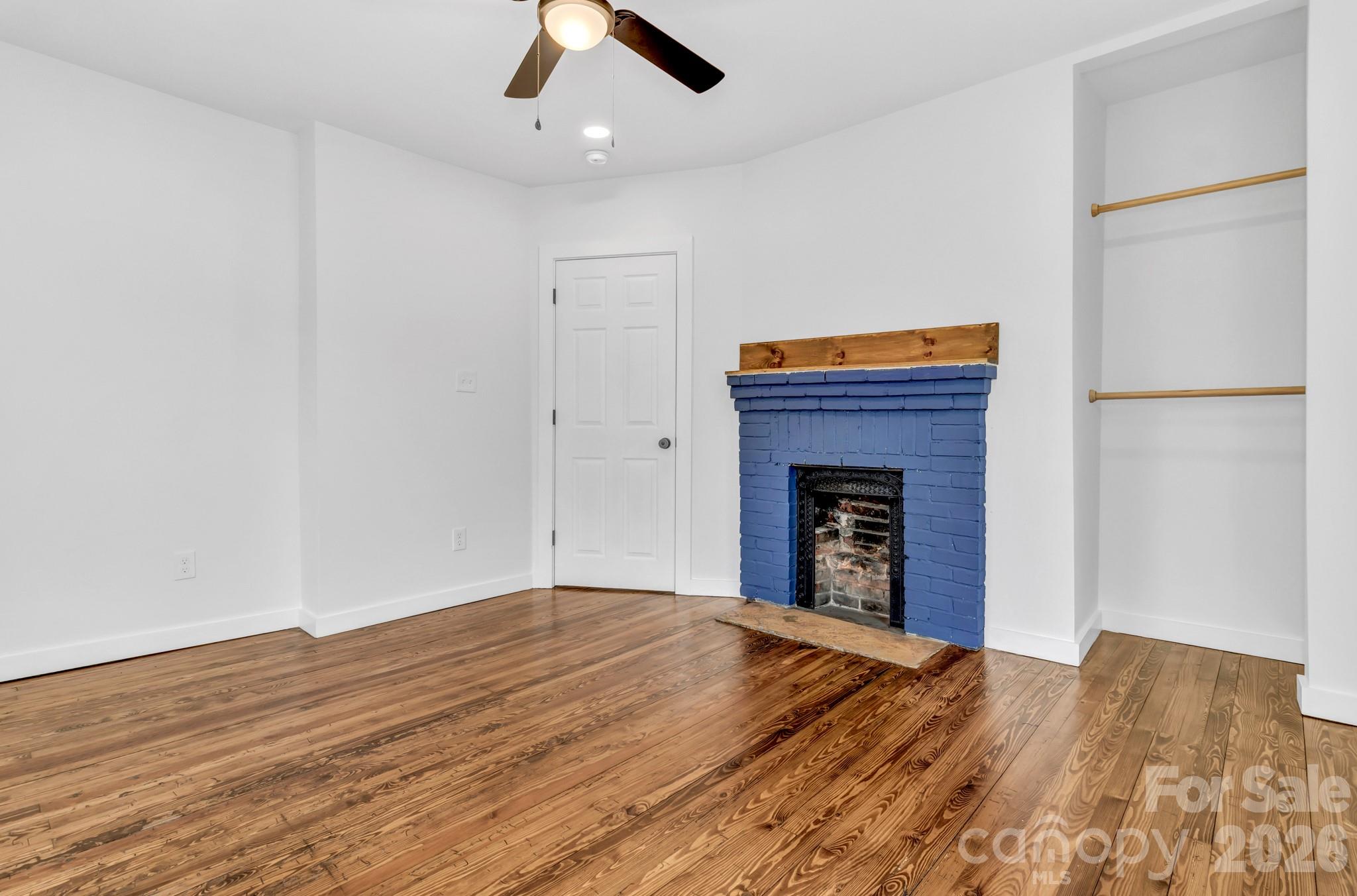 246 Marion Street Marion, NC 28752 - Photo 21 of 48 a view of an empty room with wooden floor and a fireplace