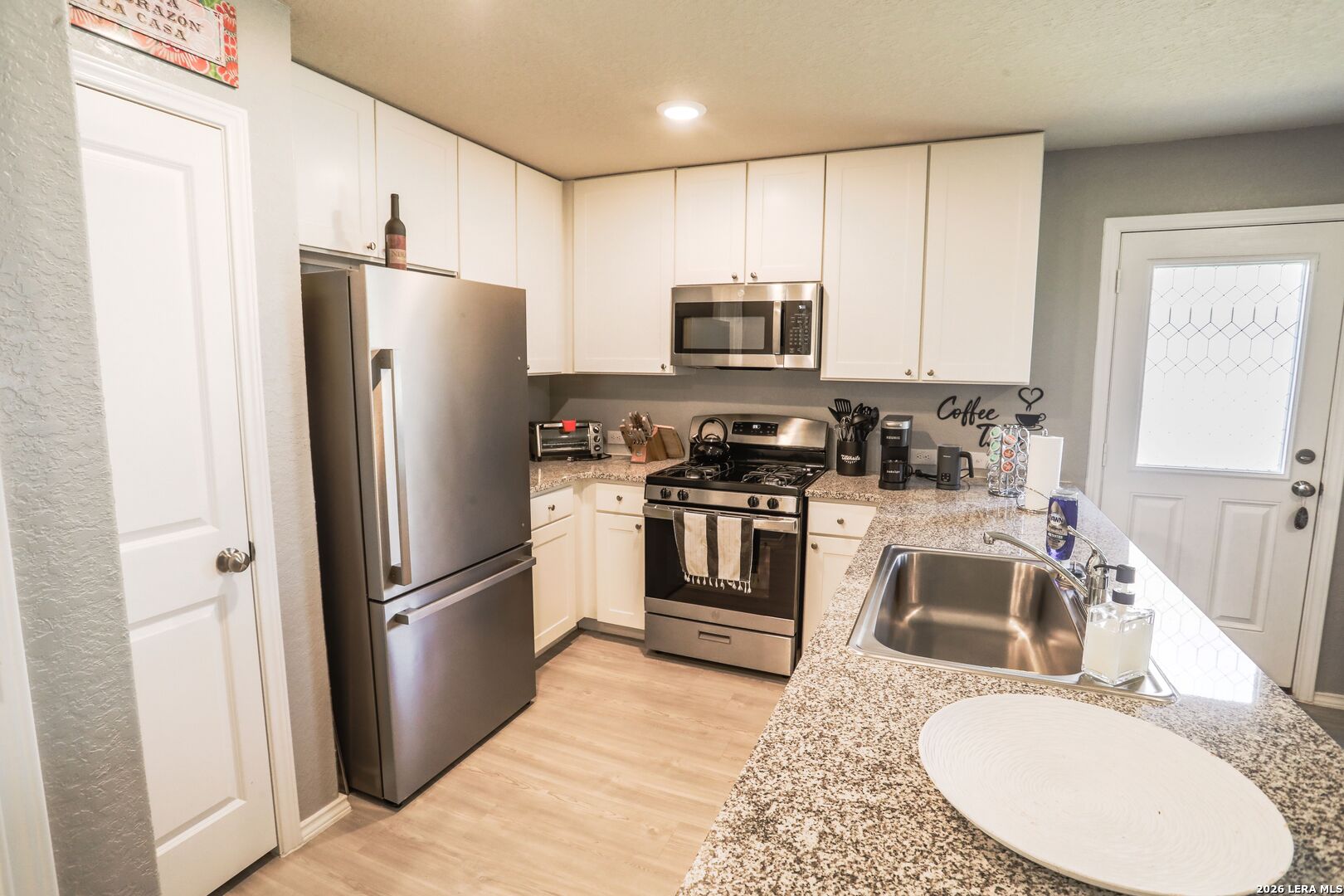 3318 Carducci Drive Converse, TX 78109 - Photo 7 of 14 a kitchen with stainless steel appliances granite countertop a refrigerator stove microwave and sink