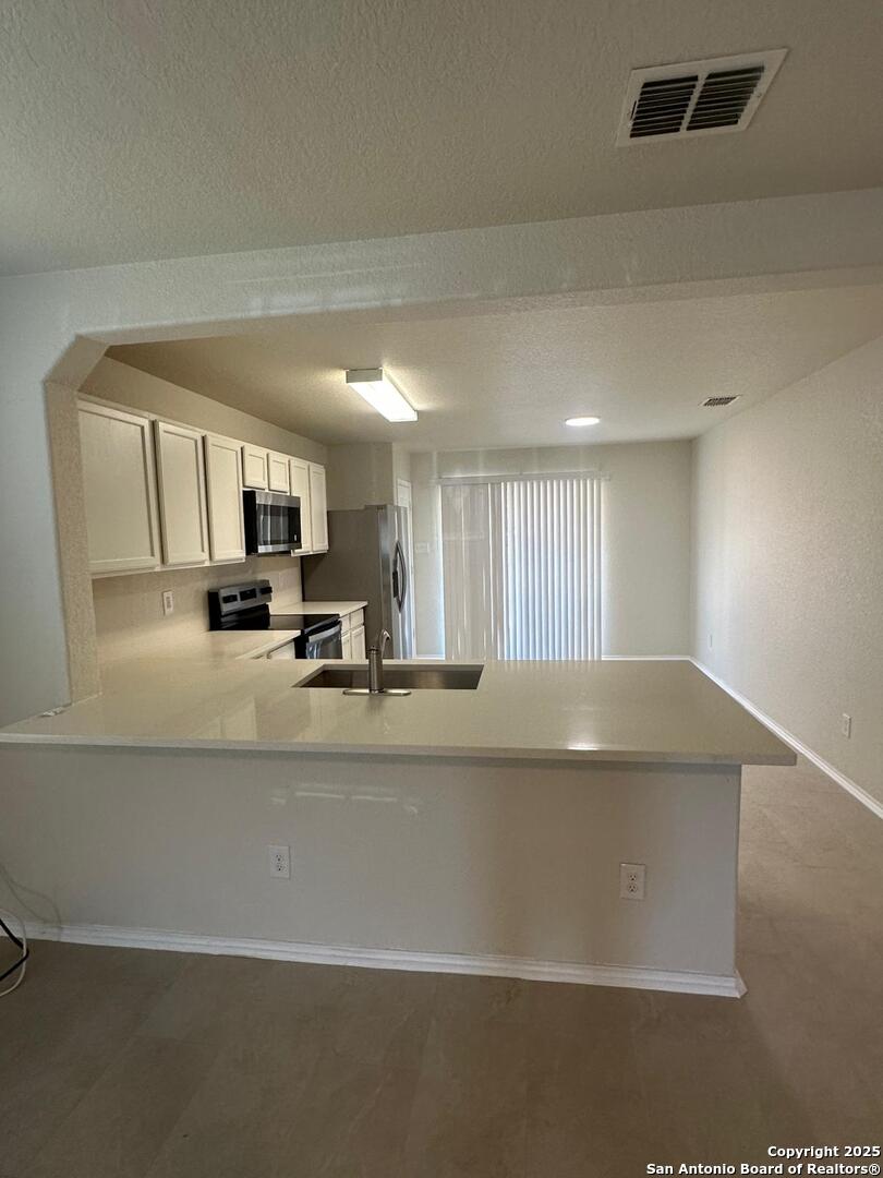 25346 Colt River San Antonio, TX 78261 - Photo 3 of 35 a view of kitchen with stainless steel appliances granite countertop white cabinets and a refrigerator