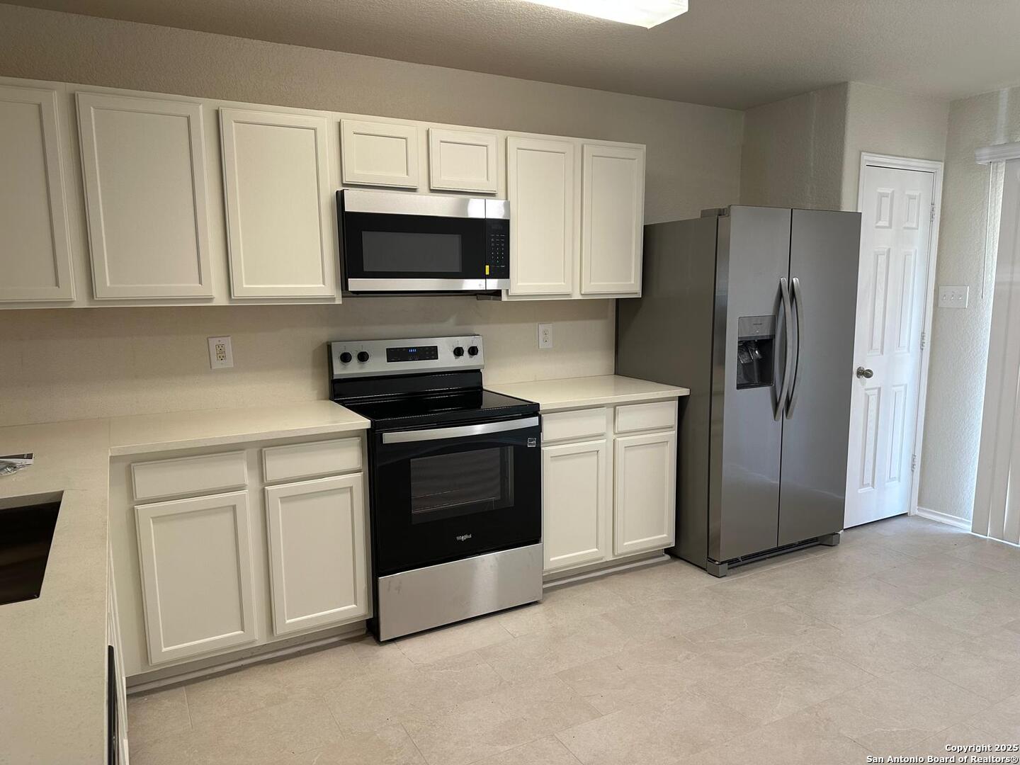 25346 Colt River San Antonio, TX 78261 - Photo 4 of 35 a kitchen with white cabinets and stainless steel appliances