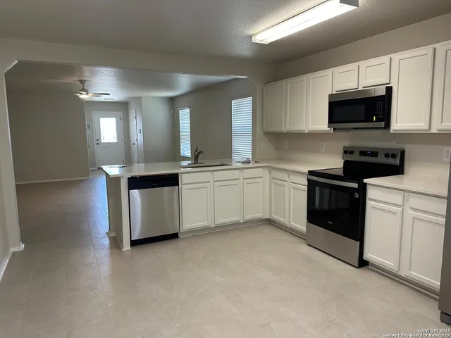 a kitchen with stainless steel appliances granite countertop a sink and a stove
