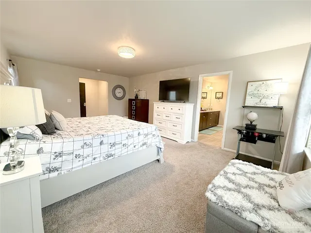 a spacious bathroom with a toilet sink double vanity and mirror