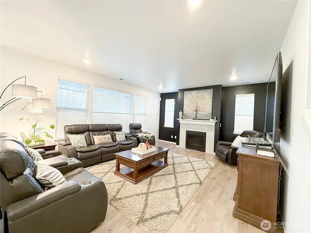 a kitchen with stainless steel appliances kitchen island granite countertop a table chairs and a view of living room