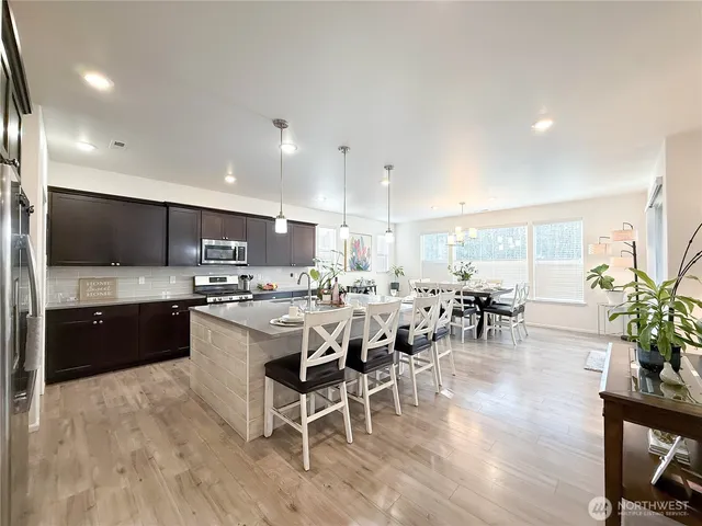 a kitchen with stainless steel appliances kitchen island granite countertop a sink and cabinets