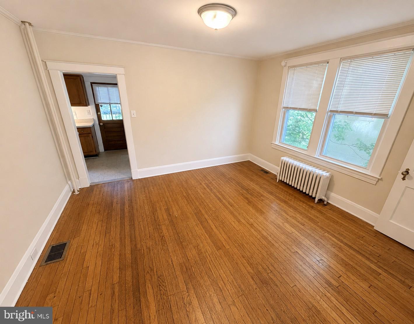 506 Cedarcroft Road Baltimore, MD 21212 - Photo 3 of 16 wooden floor in an empty room with a window