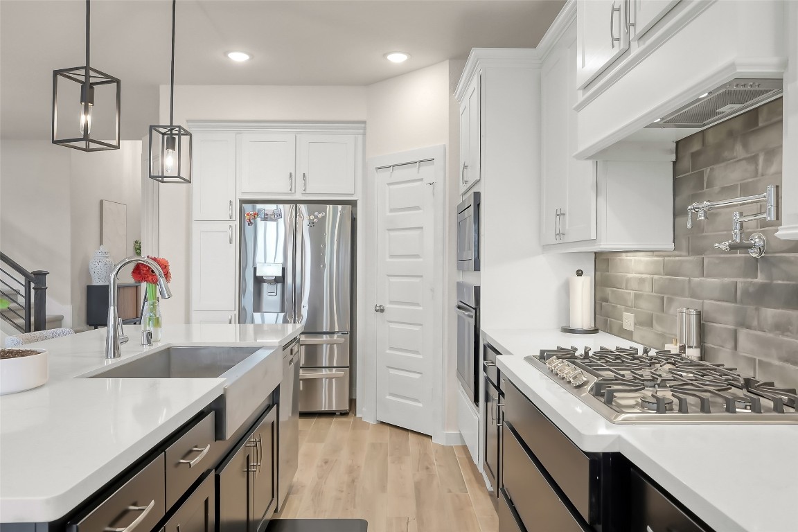 6718 Waxbill Road Katy, TX 77493 - Photo 13 of 48 a kitchen with stainless steel appliances granite countertop a sink stove and refrigerator