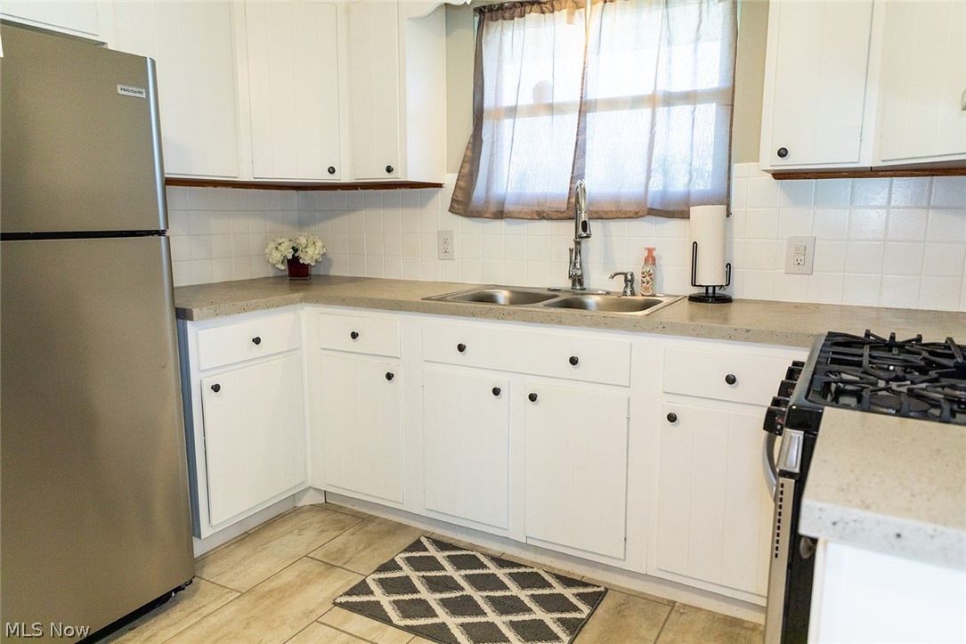 802 Dutch Ridge Road Parkersburg, WV 26104 - Photo 7 of 25 Kitchen featuring white cabinetry, stainless steel fridge, and backsplash