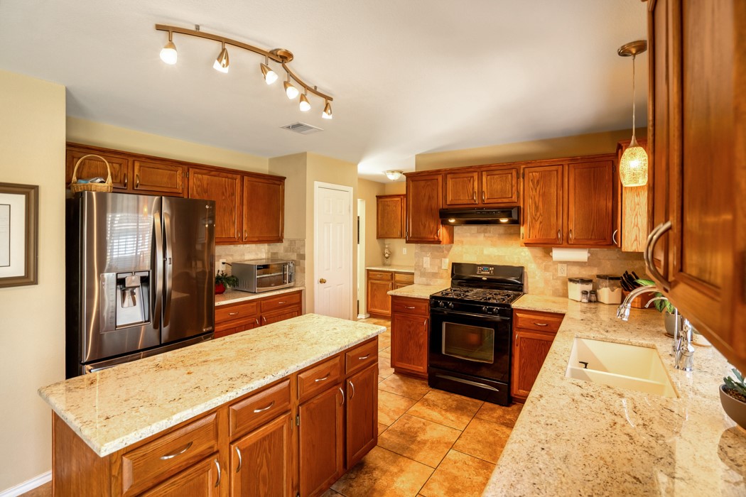 412 Derby Lane Georgetown, TX 78626 - Photo 16 of 37 a kitchen with stainless steel appliances granite countertop a stove refrigerator and sink