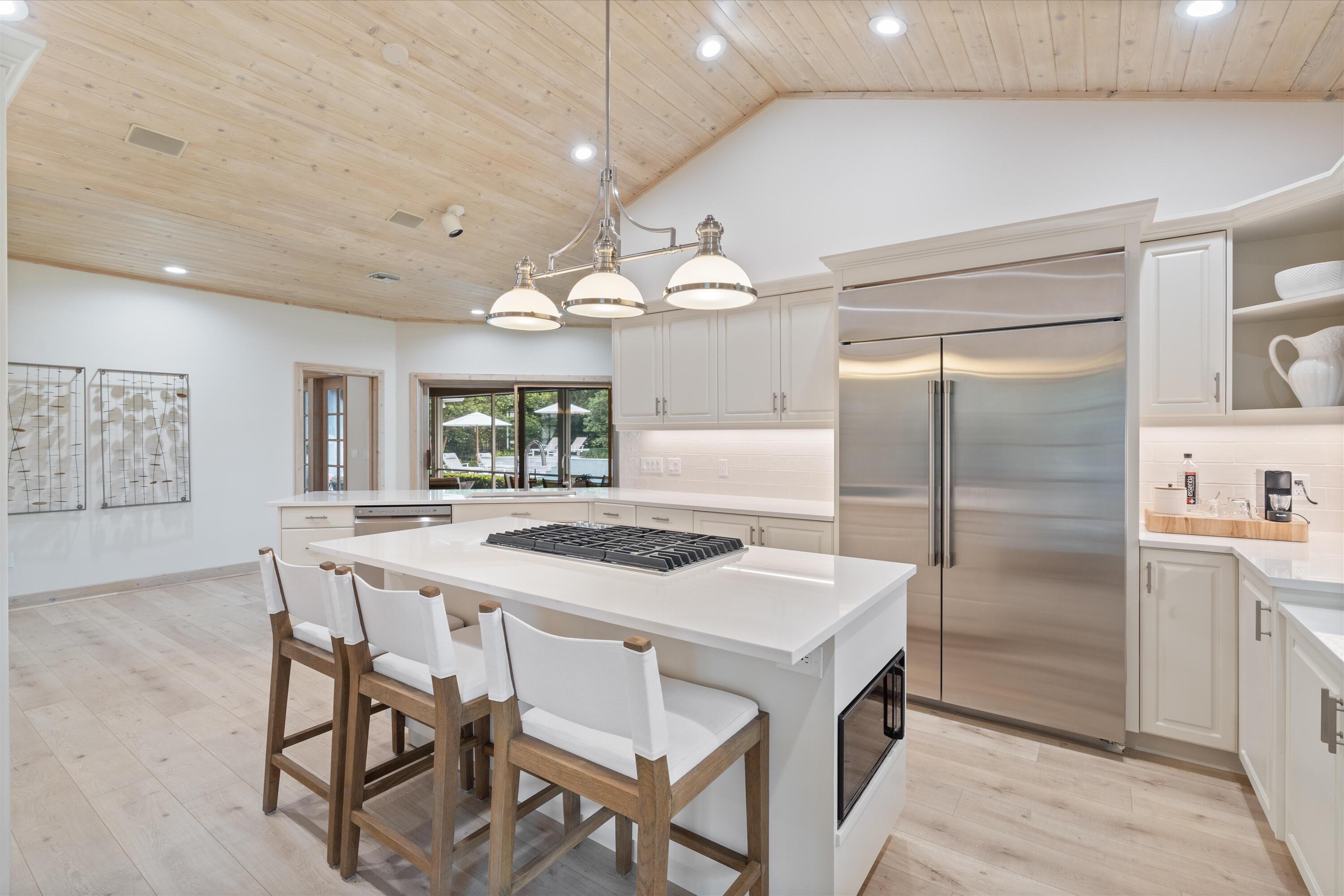 121 Turnberry Drive Atlantis, FL 33462 - Photo 9 of 47 a kitchen with stainless steel appliances granite countertop a table chairs and a refrigerator