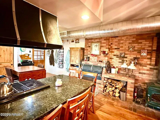 a dining room with stainless steel appliances kitchen island granite countertop furniture and a large window