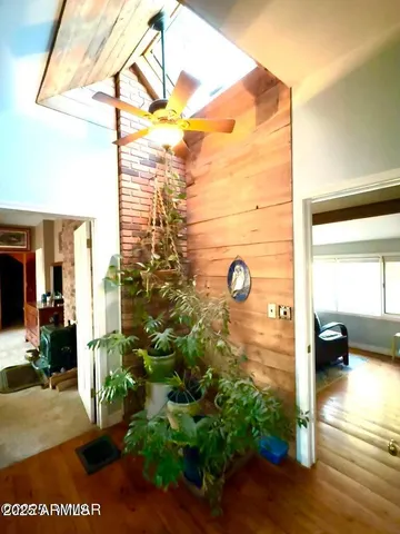 a view of a livingroom with a fireplace dining space and wooden floor
