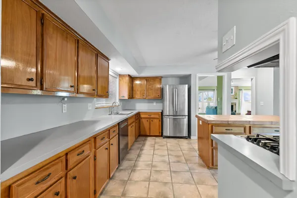 a kitchen with stainless steel appliances granite countertop a stove a sink and a refrigerator