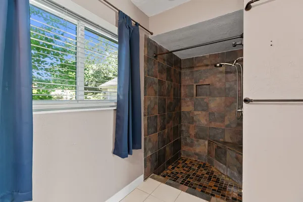 a bathroom with a toilet a sink a mirror and a window